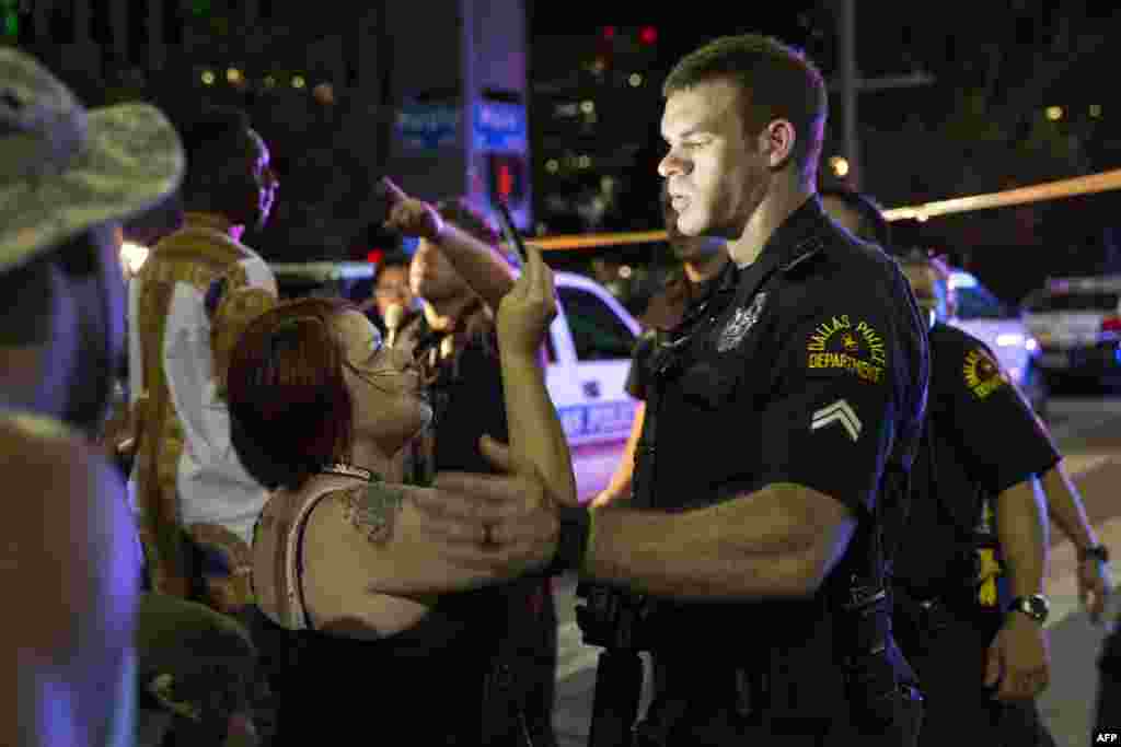 Police attempt to calm the crowd as someone is arrested following the sniper shooting in Dallas on July 7, 2016.