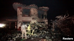 在巴格达以南的希拉市的一处加油站,伊拉克安全部队在检查自杀卡车炸弹袭击后的现场。(2016年11月24日)