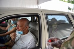 Seseorang menggunakan usap hidung untuk memberikan sampel yang akan diuji untuk COVID-19 di tempat pengujian drive-thru ketika kasus melonjak di seluruh negara bagian, di New Orleans, Louisiana, AS, 6 Agustus 2021. (Foto: Reuters)