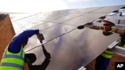 资料照片:南非沿海地区的工人正在安装太阳能电池板(2016年3月29日)
