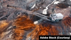 一台大型步行式挖掘机在采石场内开采稀有金属。