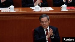 3月11日,李强在中国人大闭幕会议上鼓掌。