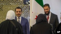 ညီလာခံ တက်ရောက်လာသူများကို ကြိုဆိုနှုတ်ဆက်နေသည့် ကြားဖြတ်အစိုးရ သမ္မတ Ahmad al-Sharaa (ယာ) နှင့် နိုင်ငံခြားရေးဝန်ကြီး Asaad al-Shibani (ဝဲ)။ (ဖေဖော်ဝါရီ ၂၅၊ ၂၀၂၅) (AP)