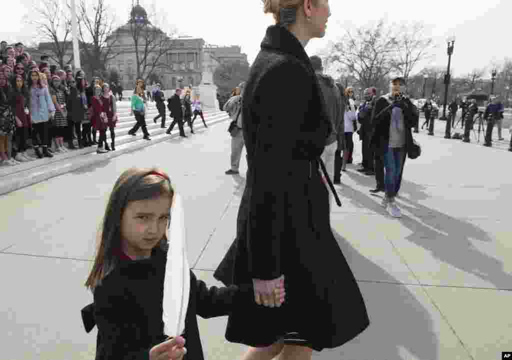 川普总统的女儿伊万卡·川普领着女儿阿拉贝拉·库什纳离开美国最高法院。此前,伊万卡应法官邀请,旁听了最高法院开庭审理案件(2017年2月22日)