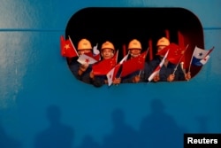 2018年12月3日,水手们在扩建后的巴拿马运河科科利船闸向中国国家主席习近平挥舞中国和巴拿马国旗。(路透社)