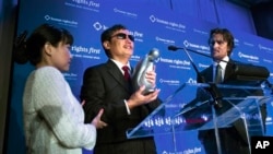 中国盲人法律活动人士陈光诚在纽约“人权第一”晚宴上接受“人权奖”,影星克里斯汀·贝尔(右)站在他身边。 (2012年10月24日)