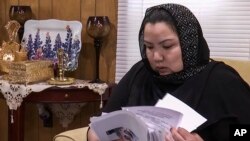 维吾尔族妇女早木热·达吾提从新疆拘留营获释后流亡美国。2020年6月15日在弗吉尼亚州伍德布里奇家中查看文件。她说:“我觉得我们的证词,我们致力于让国际社会提高认识的努力,终于得到了回报。”(美联社照片)