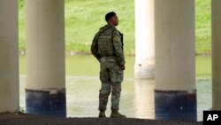 资料照:2022年9月2日,德克萨斯州国民警卫队的一名成员从美国边境眺望格兰德河对岸的墨西哥。(美联社)