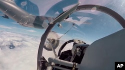 资料照片:在新华社发布的这段视频截图中,中国人民解放军东部战区空军和海军航空兵部队于2022年8月4日在某地进行空中加油。