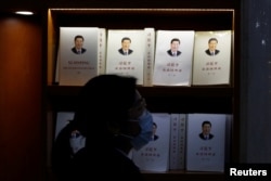 一名妇女走过北京一家书店陈列的习近平著作 (2021年3月1日)