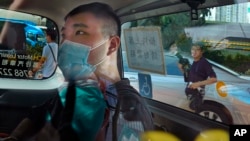 资料照:香港首位被控涉嫌违反国安法的男子唐英杰(Tong Ying-kit)坐着轮椅由警车押解至法院应讯。(2020年7月6日)