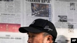 2023年2月6日,北京一男子阅读报刊有关中国间谍气球被美军击落的新闻报道后离开报亭。