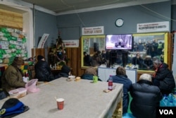 2023年1月20日,在炮弹纷飞之际,当地居民在巴赫穆特的 一处地堡观看电视。(美国之音博夏特拍摄)