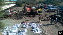 巴基斯坦一辆载有44位乘客的大巴从俾路支省的奎达开往邻近信德省的卡拉奇,行至拉斯贝拉地区的贝拉(Bela)镇时失事。图为救援人员把遇难者的遗体装入塑料袋内送往卡拉奇检测。