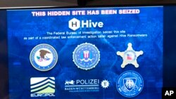 在2023年1月26日美国司法部的一场新闻发布会上,关于“蜂巢”勒索软件的信息显示在屏幕上。