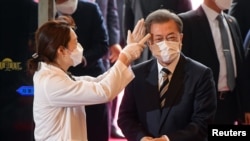 韩国总统文在寅戴着口罩在首尔的国会议事堂接受体温检测。(2020年2月28日)