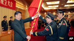 中共领导人习近平在北京举行的中国人民解放军战区成立大会上向火箭军将领、中国防长魏凤和(中)授予军旗。(2015年12月31日)