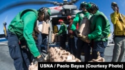 Thủy thủ trên hàng không mẫu hạm USS George Washington chất các thùng nước lên máy bay để đưa đến cho nạn nhân bão