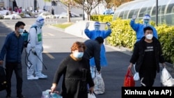 中国官媒新华社发布的照片显示,第一批上海感染新冠病毒的人康复后从上海新国际博览中心改建的方舱医院出院。(2022年4月9日)