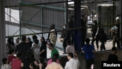 2025年2月26日,乘坐驱逐航班从美国抵达的移民站在哥斯达黎加蓬塔雷纳斯的移民临时援助中心。