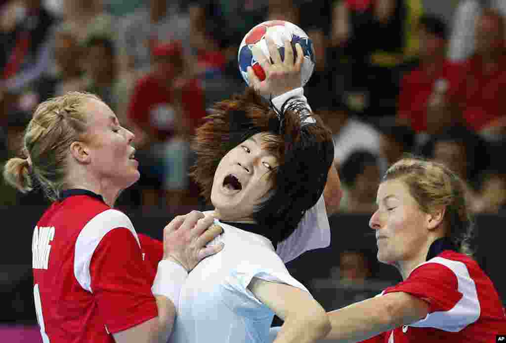 Vận động viên Hàn Quốc Jo Hyo-bi (giữa) bị 2 vận động viên Na Uy, Karoline Dyhre (trái) và Lynn-Kristin Koren (phải) kèm sát trong trận đấu bóng ném nữ sơ khởi, 1 tháng 8, 2012. (AP Photo