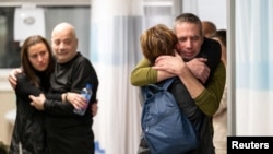 Fernando Simon Marman and Louis Hare wakiungana na wapendwa wao huko kAatika kituo cha matibabu cha Sheba huko Ramat Gan. (Reuters).