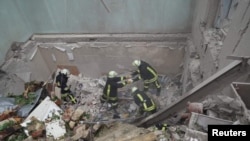 在利沃夫,救援人员在被俄罗斯导弹击中的一座居民楼废墟进行搜救工作。(2023年7月6日)