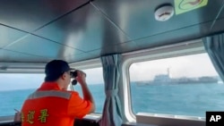 资料照:台湾海巡署发布的视频截图显示,台湾海巡署成员在台湾马祖列岛海岸附近监控一艘中国海警船航行。(2024年10月14日)