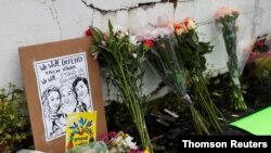 人们枪击地点摆放鲜花哀悼亚特兰大连环枪击案中遇难者。(2021年3月18日)