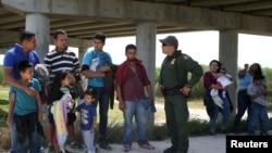 2018年4月2日,德克萨斯州麦卡伦附近的格兰德谷地区,边境巡逻员吉奥拉米雷斯与非法从墨西哥越境进入美国的移民进行对话。