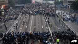 在香港警察施放催泪瓦斯后,抗议者在政府总部外与警方对峙。(2019年6月12日)