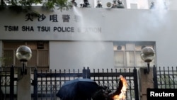 一名反送中抗议者向香港尖沙咀警察署投掷燃烧瓶。 (2019年10月20日)