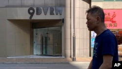 一名工人星期六(11月23日)在香港一家公司门前走过。其地址为中资的中国创新投资。(美联社)