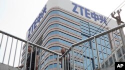 人们从北京的一座中兴大楼旁走过。(2018年5月8日)