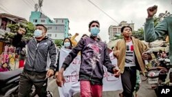 资料照片:反政府抗议者游行走过缅甸城市曼德勒的街头。(2021年12月7日)