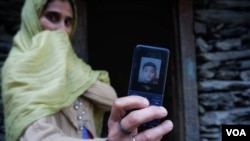 Parveena Begum menunjukkan foto putranya Shahid Ahmad Ganai, 14 tahun, yang tewas akibat serangan macan tutul di Trikanjan, Kashmir-India. (foto: Wasim Nabi/VOA)