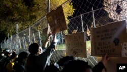 资料照片:示威者在抗议杜安特·赖特被射杀期间,举着标语牌,顶着明尼苏达州布鲁克林中心警察局外的安全围栏。(2021年4月16日)