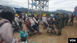 Personel TNI-POLRI melakukan pemeriksaan terhadap pekerja yang hendak memasuki pabrik smelter PT GNI di Morowali Utara, Sulawesi Tengah, 19 Januari 2023 (Foto : VOA/Yoanes Litha)