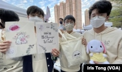 香港皇仁书院年宵筹委会主席伍正枫(右一)及成员Anthony (中)展示他们一班同学今年在荃湾南丰纱厂年宵市集售卖的自家设计”白玉兔“产品。 (美国之音 汤惠芸)
