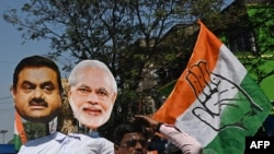 2023年2月6日在加尔各答一次集会上,一名印度国大党的活动人士高举着画有印度总理莫迪和阿达尼集团巨头高塔姆·阿达尼(Gautam Adani)画像,抗议联合政府的财政政策。