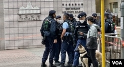 香港西九龙裁判法院大楼一幅玻璃幕墙怀疑被人射击破裂后,警方加强戒备,带同警犬在法院正门入口驻守 (美国之音/汤惠芸)