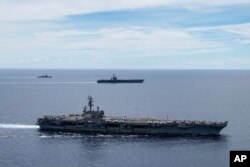 2020年8月罗纳德·里根号航空母舰和远处的尼米兹号航空母舰在南中国海一起编队航行