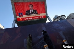 大屏幕正播放李克强在第十三届全国人大上做政府工作报告。