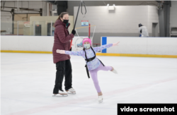 母亲是泰国裔,父亲是白人的雪利·纳瑞·韦斯特跟教练吉尔·史密斯学习新动作。(VOA视频截图)