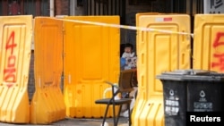 上海封城后,医护人员正在给一个小女孩做新冠病毒核酸检测。(2022年3月26日)