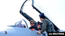 在卡姆拉空军基地举行的接装仪式上,巴基斯坦总理伊姆兰·汗坐在中国制造的歼-10C战斗机的驾驶舱内,听取介绍。(2022年3月11日)