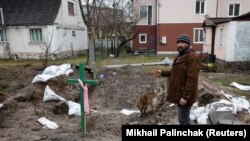 Чоловік чтоїть біля могили. Буча, 3 квітня