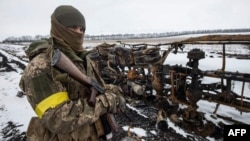 Binh sĩ Ukraine xem xét các xe quân sự bị phá hủy, ảnh do quân đội Ukraine công bố hôm 8/3, không nêu địa điểm.