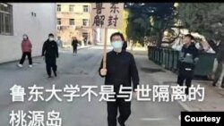 中国山东省鲁东大学研究生孙健在校园内举牌要求将校园解封。(照片来自维权网)