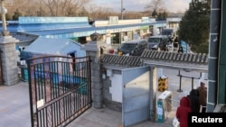 灵车在北京一家火葬场大门外排队。（2022年12月17日）